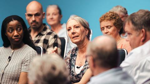 Mehrere Menschen vor einer blauen Studiowand