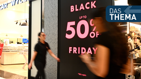 Einkaufspassage mit Schildern, die auf Rabatte zum Black Friday hinweisen