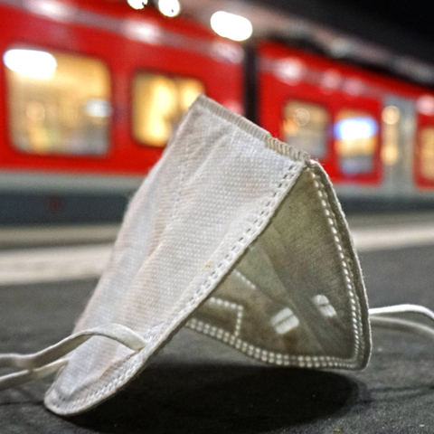 FFP2-Maske liegt an einem Bahnhof auf dem Boden