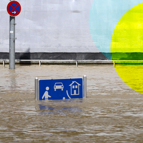 Eine überflutete Straße, aus dem Wasser ragt ein Straßenschild